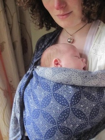 A new mum carries her tiny baby in an Oscha ring sling