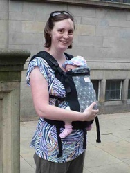 A babywearer with her baby on her front in a Beco (soft structured carrier)